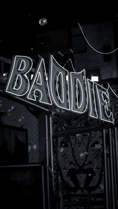 the neon sign for baddie's is lit up in black and white at night