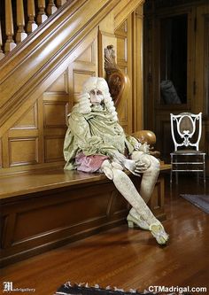 a man sitting on top of a wooden bench next to a stair case in a house