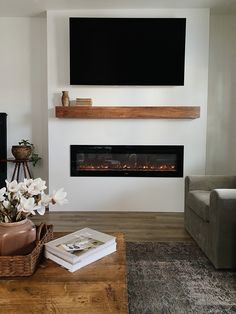 a living room with a large flat screen tv mounted on the wall above a fireplace