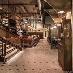 the interior of a restaurant with stairs leading up to an upper level bar and seating area