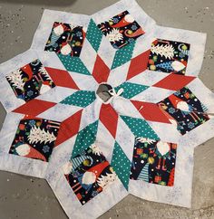 a quilted table topper with christmas decorations on it