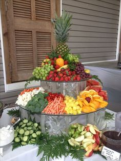 an assortment of fresh fruits and vegetables on a buffet table at a wedding or party