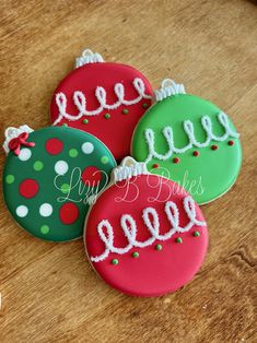 three decorated cookies sitting on top of a wooden table