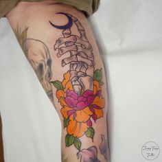 a tattoo with a skeleton and flowers on it's arm is seen in this image