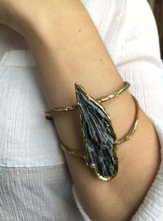 Inspired from the texture of the night's sky; Black kyanite is embedded in brass to create this sculptural cuff. This bracelet is slightly adjustable by gently squeezing the metal. Length 2 1/4" Width 1" Diameter 2 1/2" Bracelet Opening 1" This piece is handmade-to-order, please allow 1 - 2 weeks to ship unless this piece is in stock. Each piece will vary slightly due to the uniqueness of the stones. All metal is nickel free. Black Kyanite Jewelry, Metal Bracelet Ideas, Handmade Metal Jewelry, Rough Stone Jewelry, Soft Soldering, Soft Solder, Black Kyanite, Raw Stone Jewelry, Sculptural Jewelry