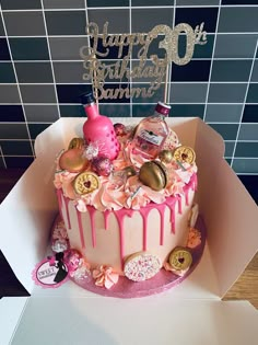 a birthday cake with pink icing and decorations