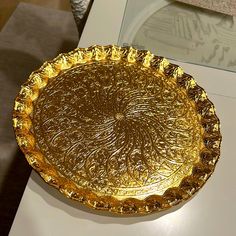 a gold plate sitting on top of a white table