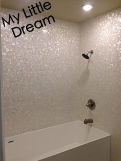 a white bath tub sitting inside of a bathroom next to a shower head and faucet