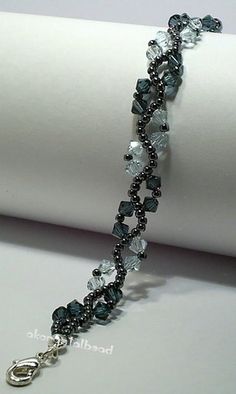 a beaded bracelet with black beads and silver clasps on a white napkin roll