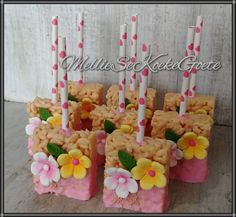 there are many small cakes with candles in the shape of squares and flowers on them