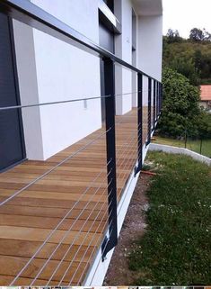 a wooden deck next to a building with metal railings on the outside and inside