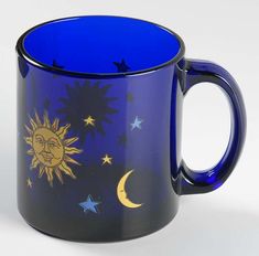 a blue coffee mug with the sun and moon painted on it's side, sitting in front of a white background