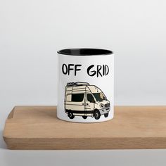 an off grid camper mug sitting on top of a wooden shelf with the words off grid printed on it