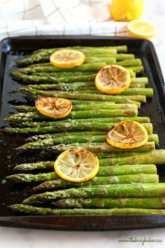 asparagus and lemons on a baking sheet