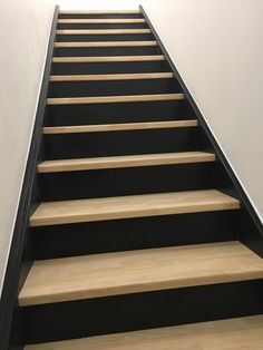 there is a set of stairs that are painted black and white with wood treads