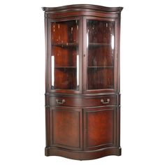 a wooden china cabinet with glass doors on the top and bottom shelves, in an antique style