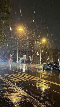 cars are parked on the side of the road in the rain as it is raining