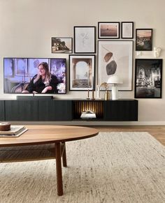 a living room with pictures on the wall and a coffee table in front of it