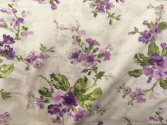 the fabric has purple and green flowers on it