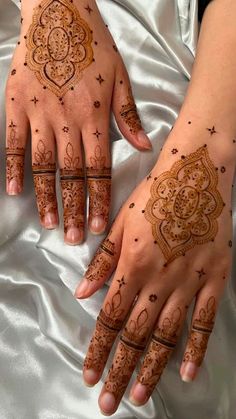 two hands with henna tattoos on them