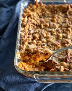 a casserole dish with a spoon in it and some food on the side