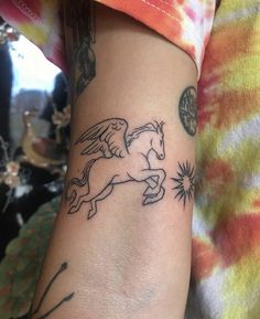 a woman's arm with a tattoo on it that has an image of a horse