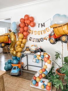 a room filled with balloons and toys in the shape of trucks