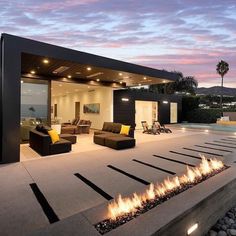 an outdoor fire pit in front of a modern home