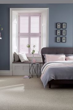 a bedroom with blue walls and carpeted flooring