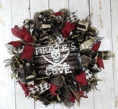 a wreath with pirate's paradise on it is hanging on a white wooden wall