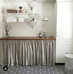 a kitchen with a sink, counter and shelves