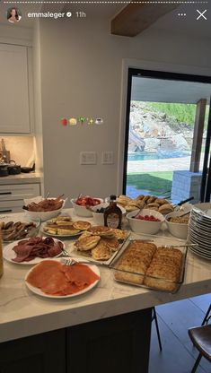 a table filled with lots of food on top of a kitchen counter