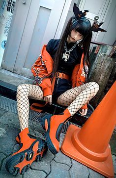 a woman sitting on top of an orange bench wearing fishnet stockings and high heels