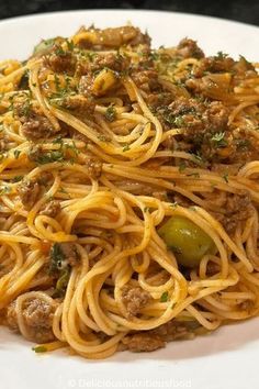 spaghetti with meat and vegetables on a white plate