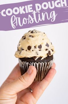 a hand holding a chocolate chip cookie dough frosting cupcake