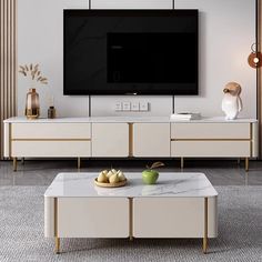 a living room with white furniture and a flat screen tv mounted on the wall above it