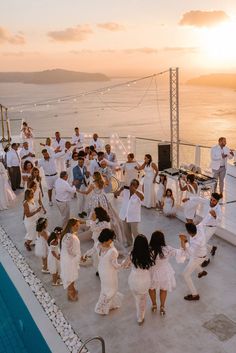 a group of people dancing on the deck of a cruise ship at sunset or sunrise