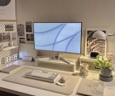 a computer monitor sitting on top of a desk next to a keyboard and mouse pad