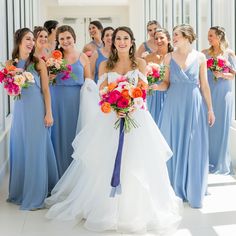 a bride and her bridal party posing for a photo in the hallway at their wedding