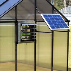 a small greenhouse with a solar panel on the roof and sidewalls that are open