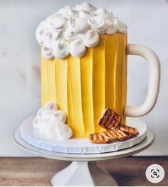 there is a cake that looks like a beer mug with whipped cream on top and pretzels next to it