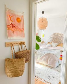 a room with a bed, rugs and baskets hanging on the wall next to it