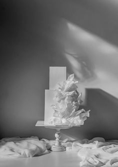 a white cake sitting on top of a table covered in frosted paper and icing