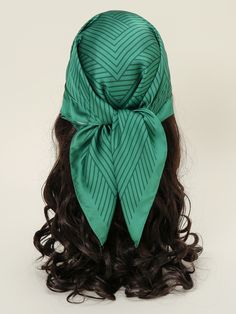 a woman's head with long hair and a green scarf on top of it