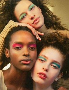 three models with different makeup looks posing for the camera