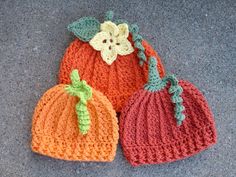 three crocheted pumpkins are sitting on the floor