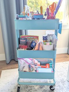 a blue cart filled with lots of craft supplies