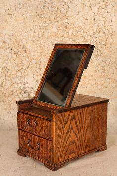 an old wooden box with a mirror in it's lid on a counter top