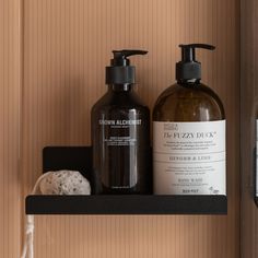 two bottles of soap and lotion sitting on a shelf