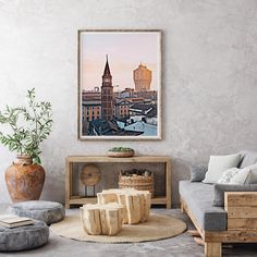 a living room filled with furniture and a painting hanging on the wall over a coffee table